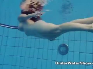 Redheaded seductress svømming naken i den basseng